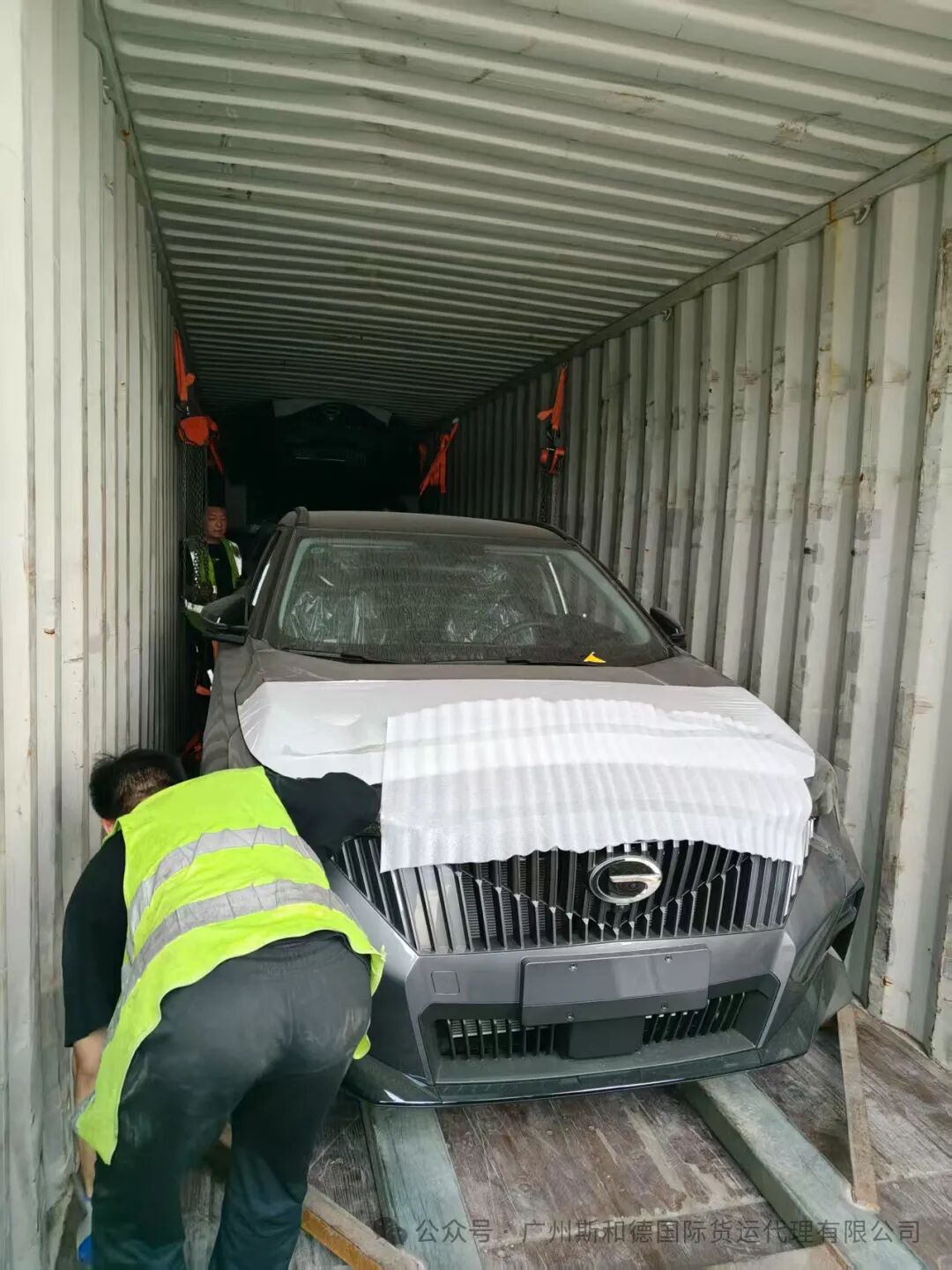 Full view of the third vehicle being loaded into the container