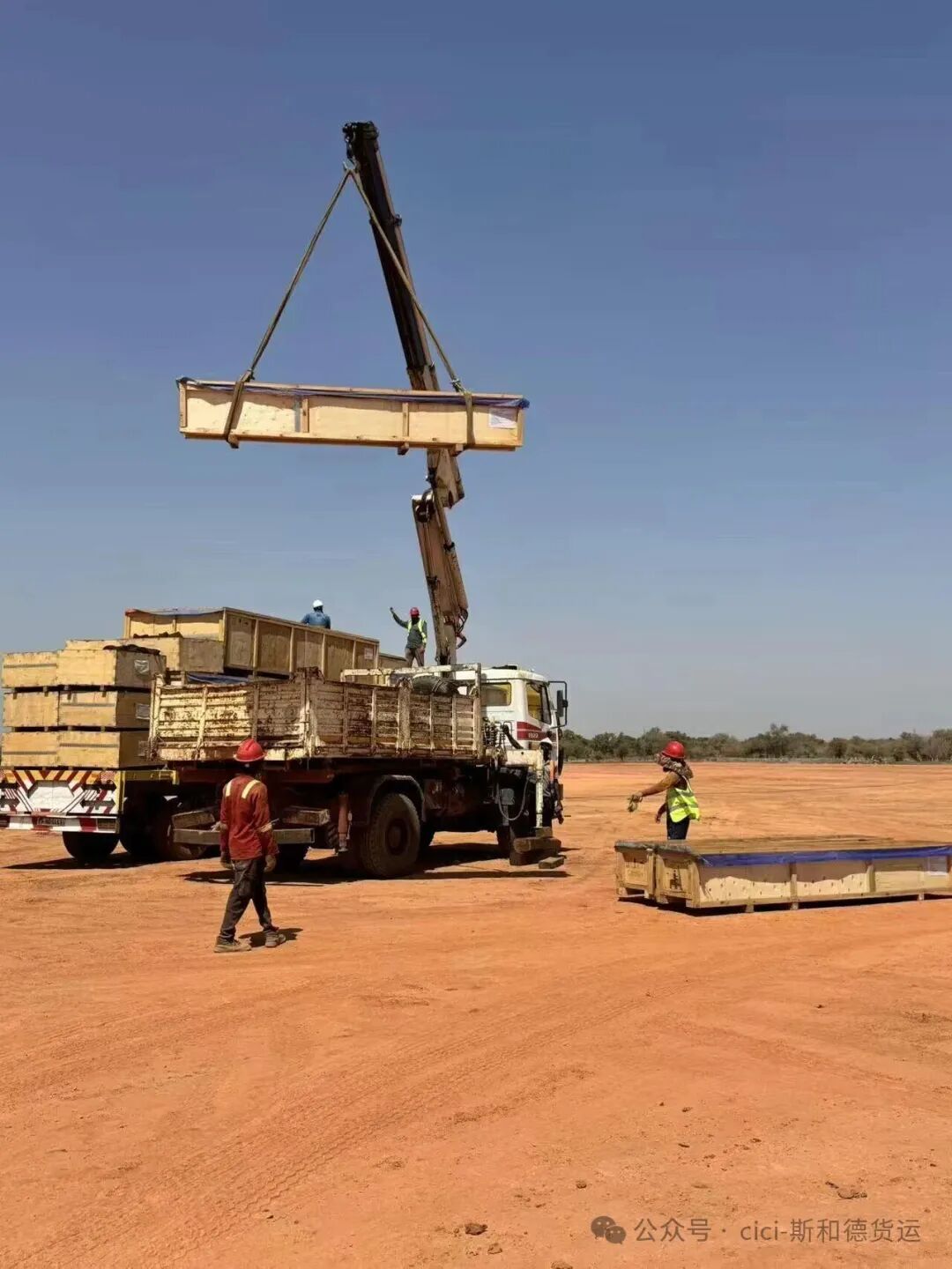 Heavy crane unloading wooden crates of project accessories in Burkina Faso
