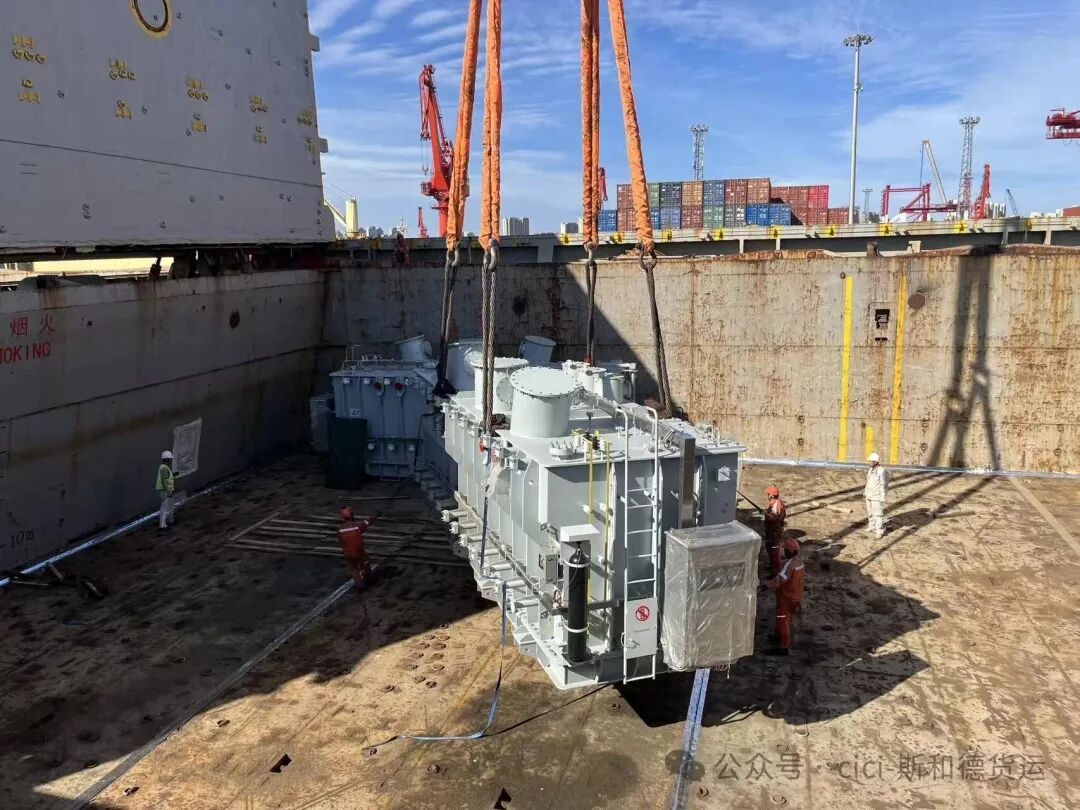 128-ton transformer just landed inside the vessel hold, with the deck crew supervising the touch-down