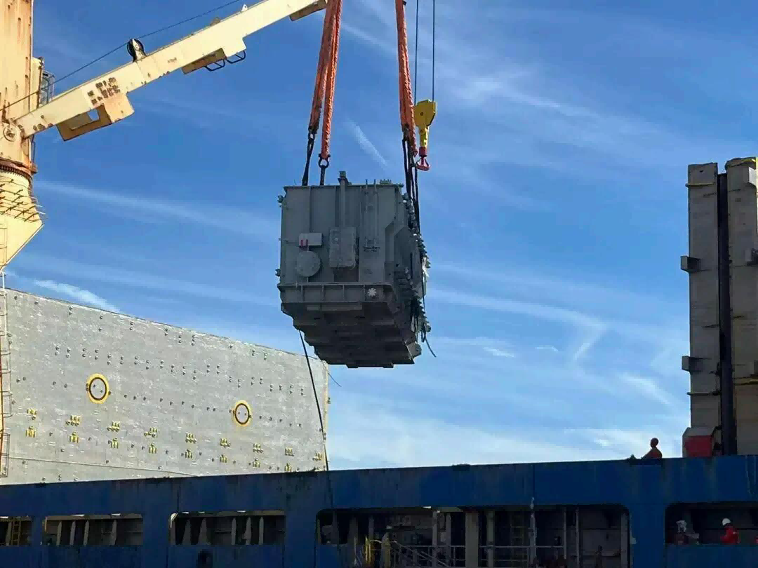 128-ton power transformer just lifted clear of the apron, suspended under the deck crane