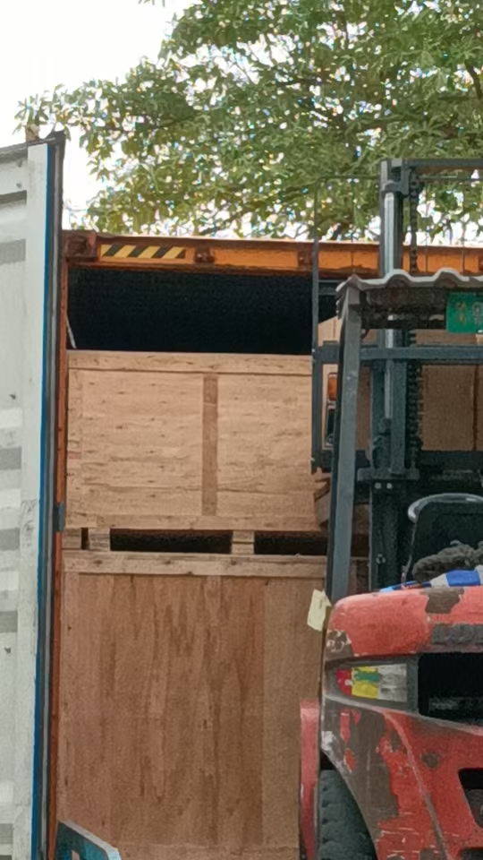 LCL cargo wooden crates loading into container with forklift