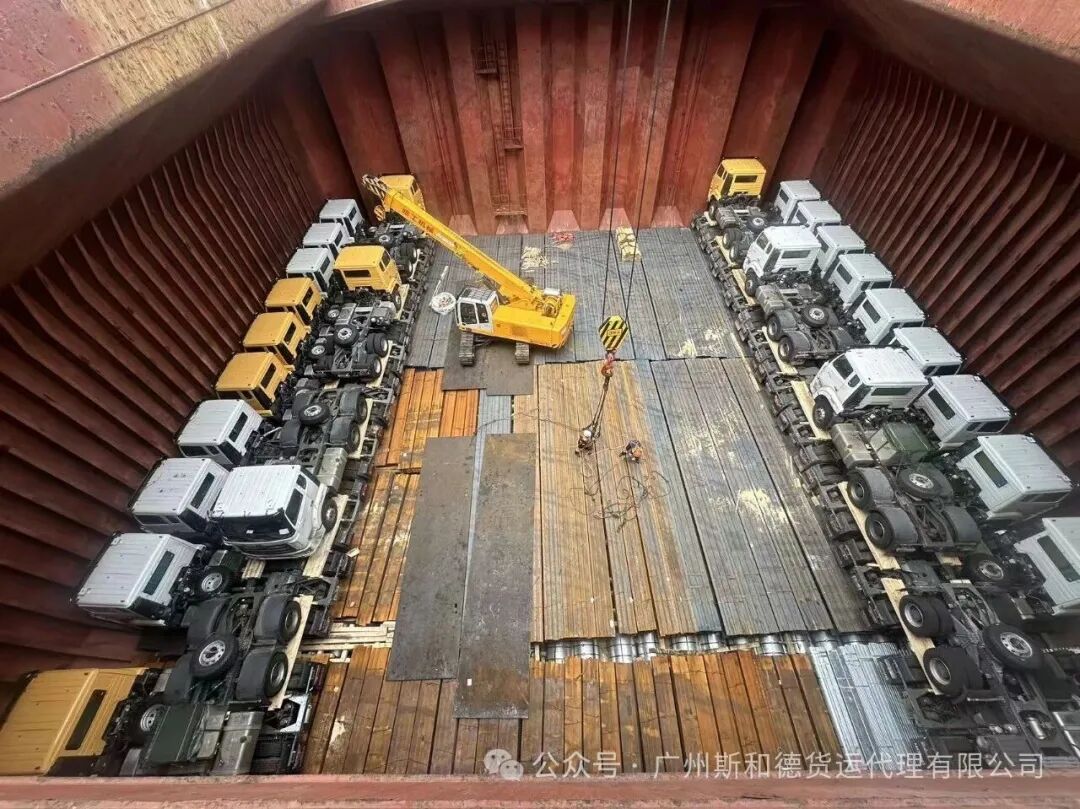 Tractor units, tippers and trucks loaded inside a vessel hold for shipment to Tema, Ghana
